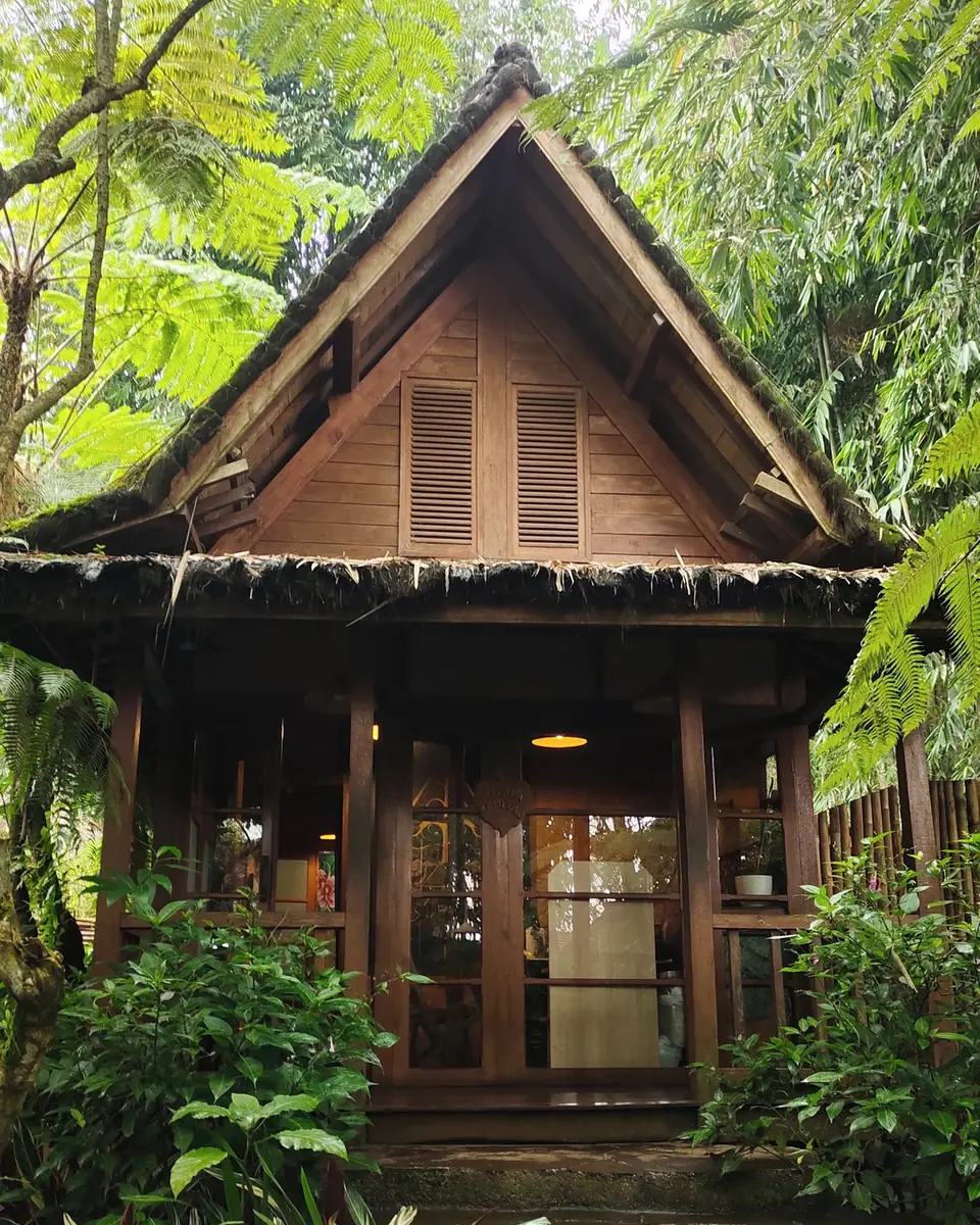 Rumah kayu berukir di kebun lebat